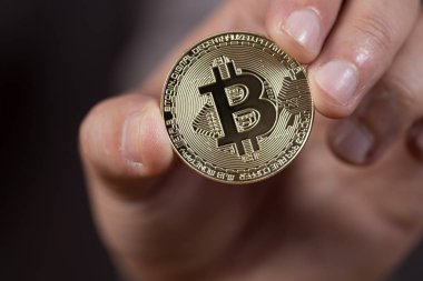 bir bitcoin, bir dijital Kripto para tutan erkek el.