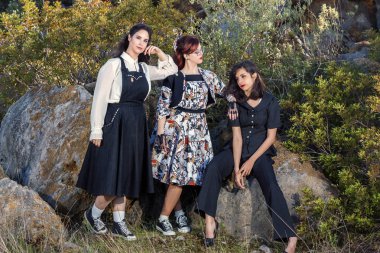 Üç kız doğa vintage giyim ile poz grubu.