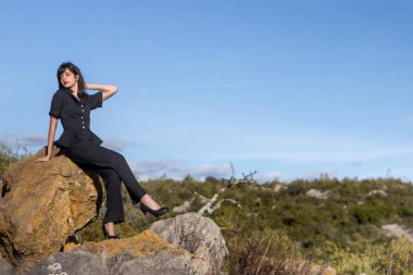 Vintage giyim ile doğada kaya üzerine poz kız.