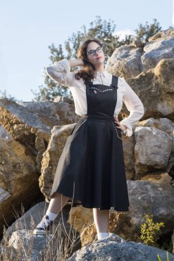 Vintage giyim ile doğada kaya üzerine poz kız.