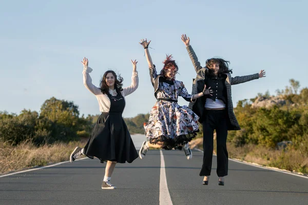 Ragazze Che Saltano Mezzo Alla Strada Con Abiti Vintage — Foto Stock