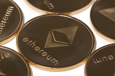 Beyaz bir arka plan üzerinde parlak altın ethereum paraları.