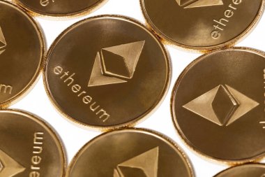 Beyaz bir arka plan üzerinde parlak altın ethereum paraları.