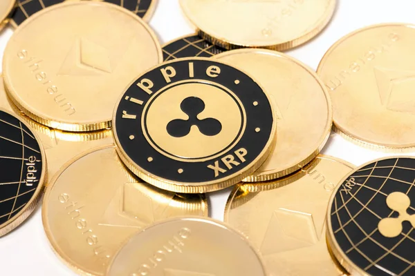 Shiny golden and black ripple coins over a white background.