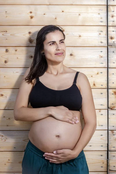 Pregnant woman poses with hands on belly — ストック写真