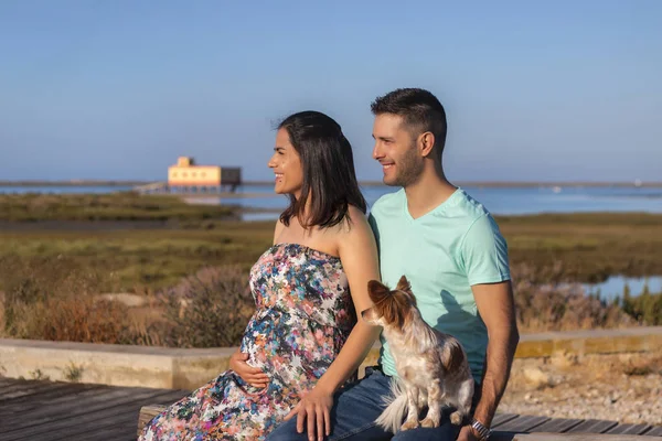 Embarazada feliz pareja con pequeño perro — Foto de Stock