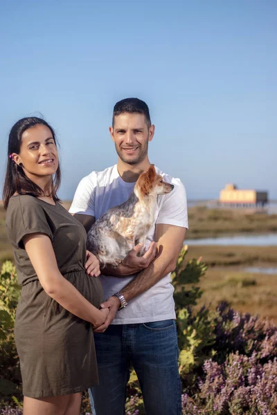 Pregnant happy couple with small dog — Stock Photo, Image