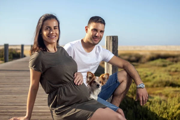 Pregnant happy couple with small dog — ストック写真