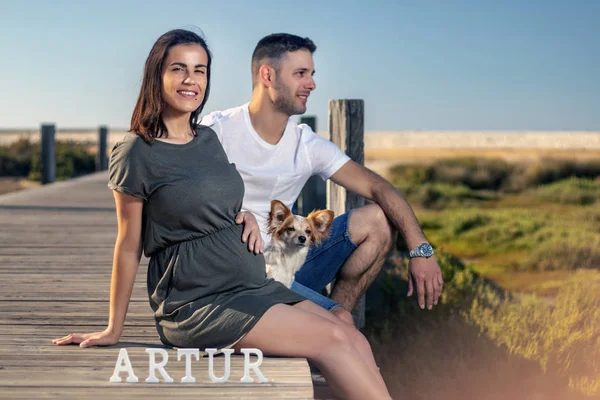 Embarazada feliz pareja con pequeño perro — Foto de Stock