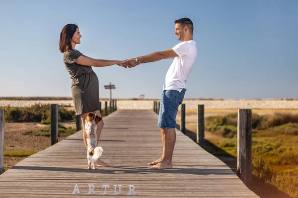 Embarazada feliz pareja con pequeño perro — Foto de Stock