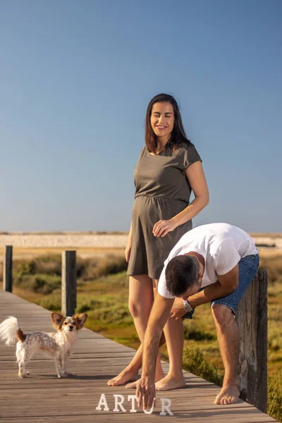 Pregnant happy couple with small dog — Stock Photo, Image