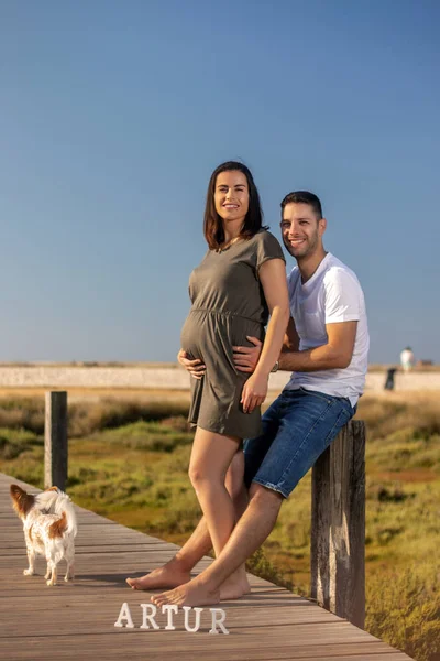 Pregnant happy couple with small dog — ストック写真
