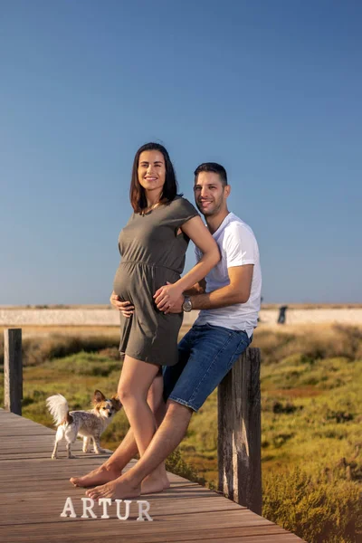 Pregnant happy couple with small dog — ストック写真