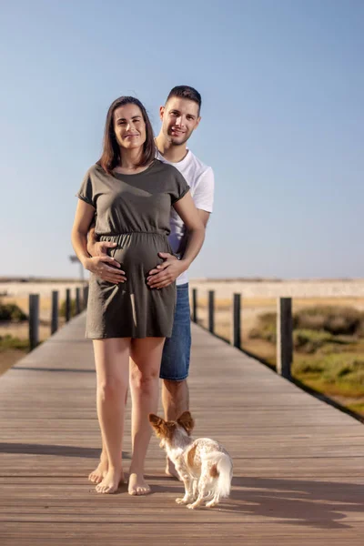 Pregnant happy couple with small dog — 스톡 사진