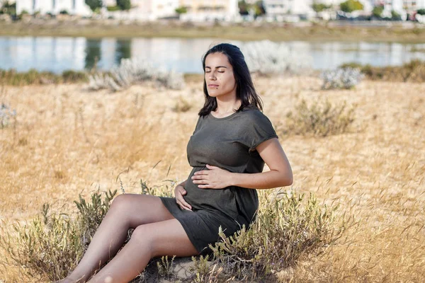 怀孕的女人在沙丘上摆姿势 — 图库照片