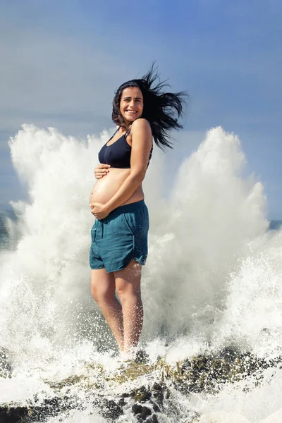 Mutlu hamile bir kadının arkasında büyük bir damla su.