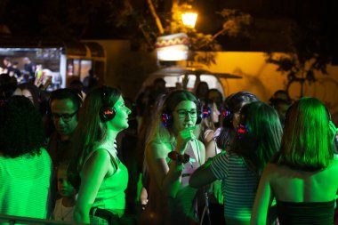 Sessiz partide dinleyiciler kulaklık kullanıyor.