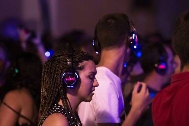 Sessiz partide dinleyiciler kulaklık kullanıyor.