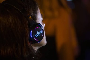 Sessiz partide dinleyiciler kulaklık kullanıyor.