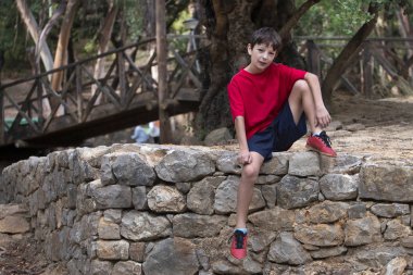 Spor kıyafetleriyle poz veren tatlı çocuk.