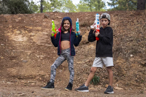 Cute girl and boy with water guns — Stock Photo, Image