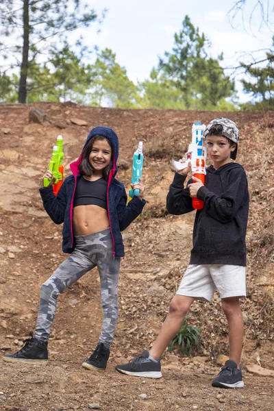 Cute girl and boy with water guns — Stock Photo, Image