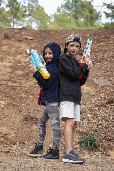 Cute girl and boy with water guns — Stock Photo, Image