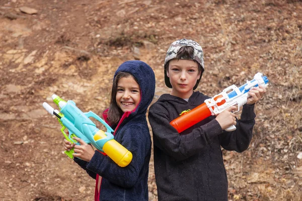 Cute girl and boy with water guns — Stock Photo, Image