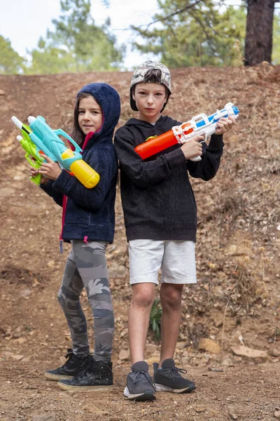 Cute girl and boy with water guns — Stock Photo, Image