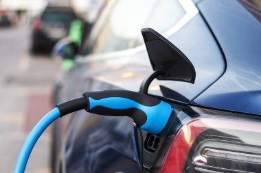 Şarj istasyonuna bağlı bir elektrikli arabanın yakın görüntüsü.