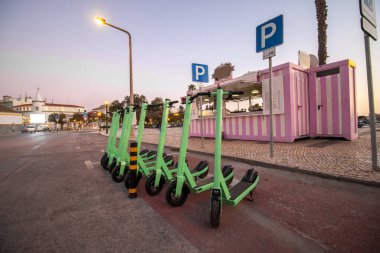 Şehirde park edilmiş yeşil elektrikli scooter 'lar..