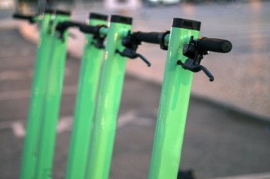 Şehirde park edilmiş yeşil elektrikli scooter 'lar..