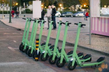 Şehirde park edilmiş yeşil elektrikli scooter 'lar..