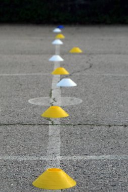 Beton bir alandaki birkaç futbol açık hava işaretçisinin yakın görüntüsü.