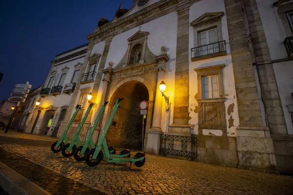 Green electric scooters for rent parked on the city.