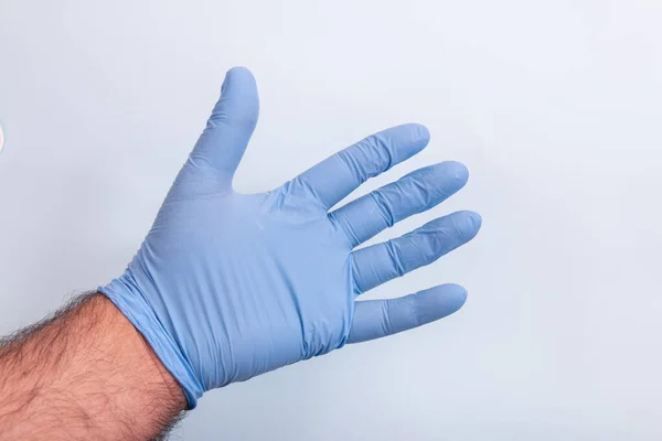 Dokters Hand Een Blauwe Medische Handschoen Een Lichtblauwe Achtergrond — Stockfoto