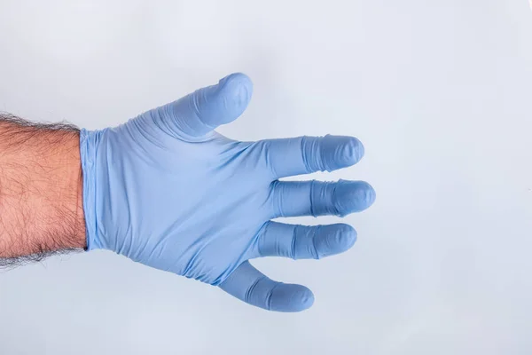 Dokters Hand Een Blauwe Medische Handschoen Een Lichtblauwe Achtergrond — Stockfoto
