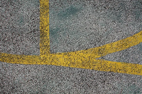 城市足球场黄线白色卵石灰蒙蒙沥青路面纹理的近景 — 图库照片
