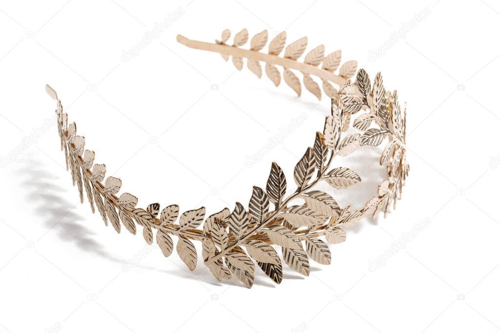 Close up view of a golden leaf tiara headband isolated on a white background.