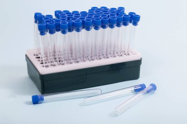 Mavi arkaplanda izole edilmiş test tüpleriyle dolu küçük raf.