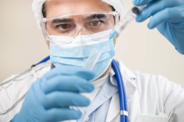 Beyaz arka planda şırıngası ve test tüpü olan beyaz bir doktor görüntüsü.