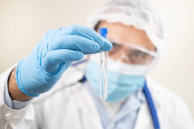 Beyaz arka planda test tüpü olan beyaz bir doktor görüntüsü.