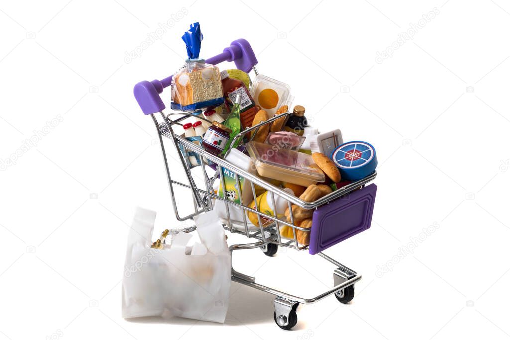 Miniature shopping cart  full with goods isolated on white background.