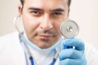 Beyaz arka planda steteskop portresi olan beyaz bir doktor..