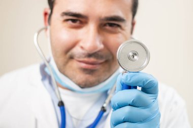 Beyaz arka planda steteskop portresi olan beyaz bir doktor..