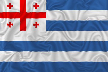 Dalgalı ipek kumaş arka planında Adjara Özerk Cumhuriyeti bayrağı.