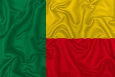 Dalgalı ipek kumaş arka planında Benin ülke bayrağı.