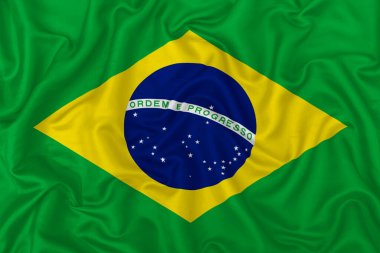 Brazil country flag on wavy silk textile fabric background. clipart