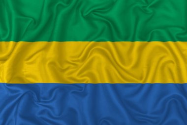Dalgalı ipek kumaş arka planında Gabon ülke bayrağı.