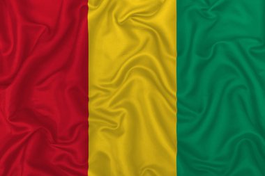 Dalgalı ipek kumaş arka planında Gine bayrağı.